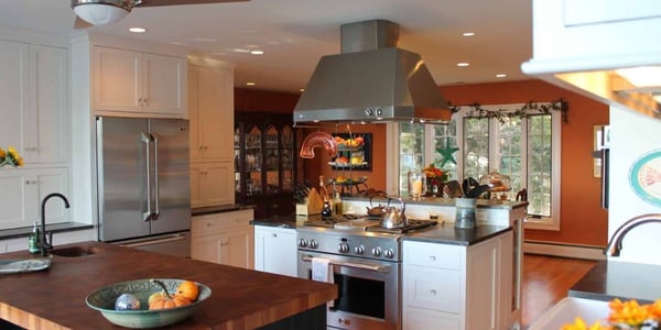 Dual island kitchen layout in Southern Maryland with white cabinets, wood countertops, and stainless steel appliances
