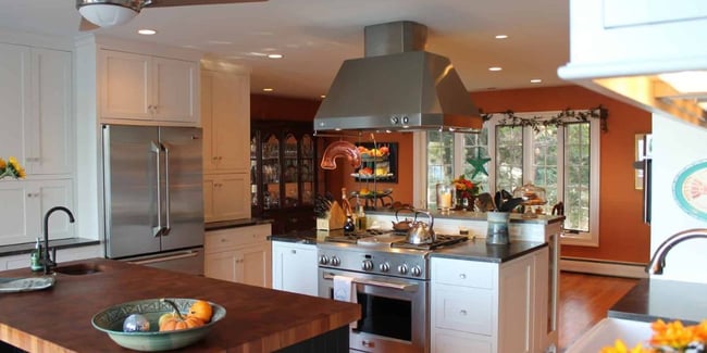 Dual island kitchen layout in Southern Maryland with white cabinets, wood countertops, and stainless steel appliances