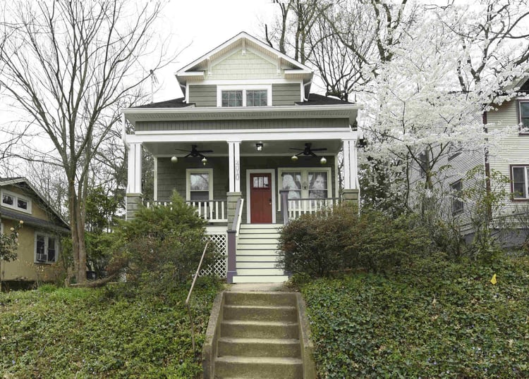 Craftsman-style home with a red door and a white-trimmed porch, remodeled by Villa Builders in Annapolis, MD