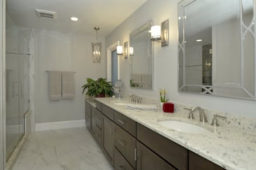 A luxury remodeled bathroom in a single-family home in Southern Maryland with dual faucets and a porcelain vanity. 