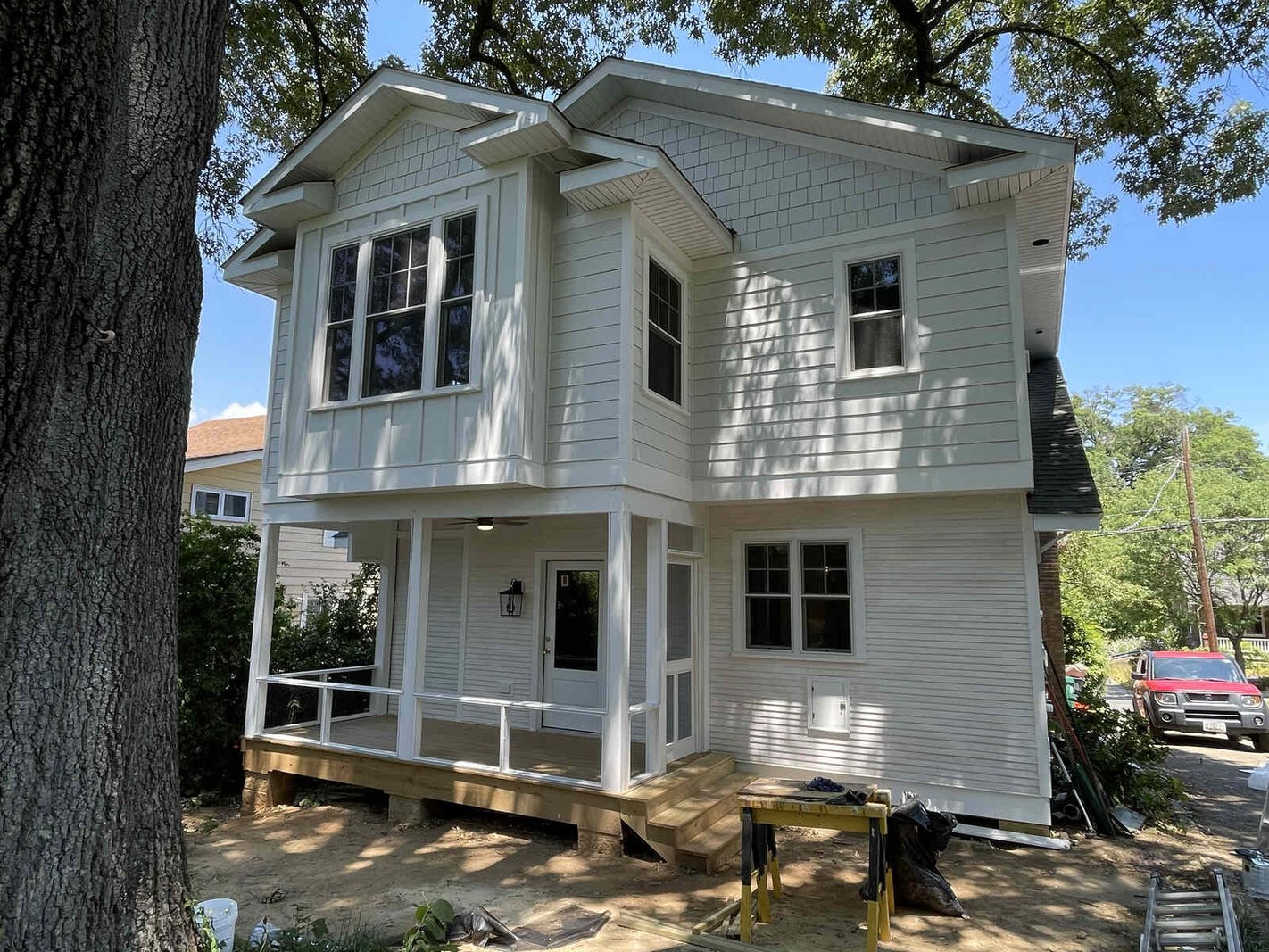 A remodeled white two-story historic home with a front porch by Villa Builders in Maryland