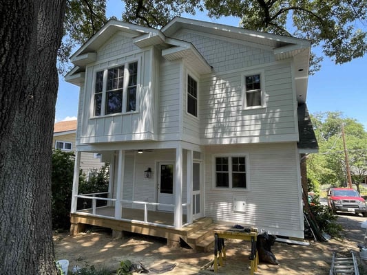 A remodeled white two-story historic home with a front porch by Villa Builders in Annapolis, MD