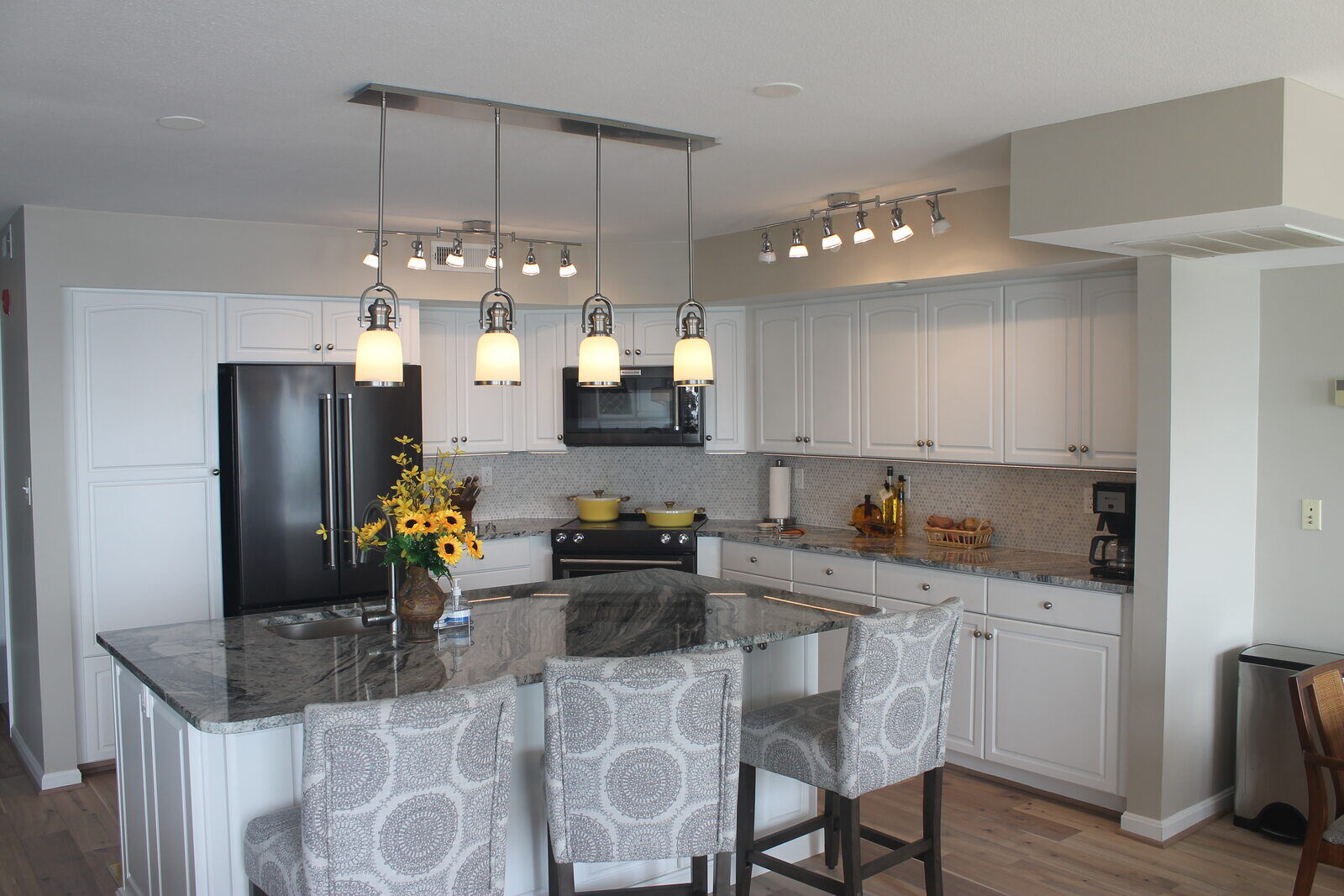 Spacious kitchen remodel with pendant lighting and a granite countertop island by Villa Builders in Annapolis, MD