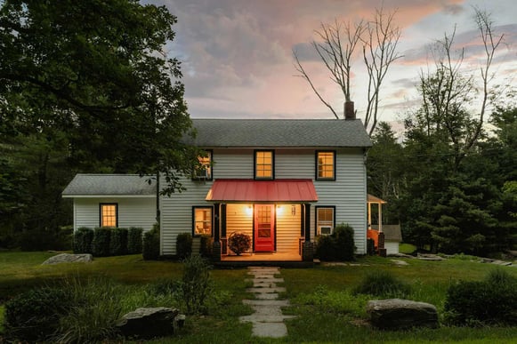 Charming countryside home with a red door and warm evening lighting, captured during a sunset in Southern Maryland
