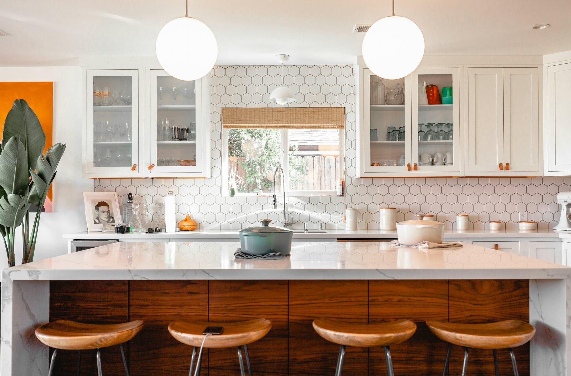 Mid-century modern kitchen with geometric backsplash and stylish wooden bar stools by Villa Builders in Southern Maryland