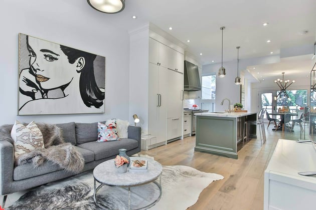 Open-concept living and kitchen space with modern artwork and minimalist decor, remodeled by Villa Builders in Southern Maryland