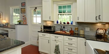 L-shaped kitchen layout in Southern Maryland with black, granite countertops and white cabinet