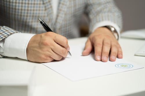 Image of a man reviewing and signing a document