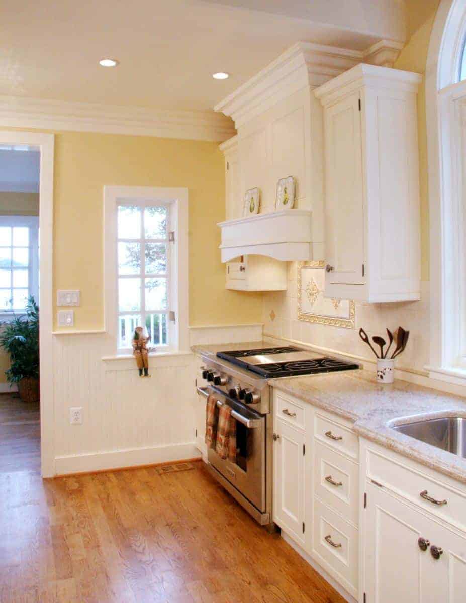 Close-up view of a remodeled kitchens cooking area with a stainless steel stove and white cabinetry by Villa Builders in Annapolis, Maryland