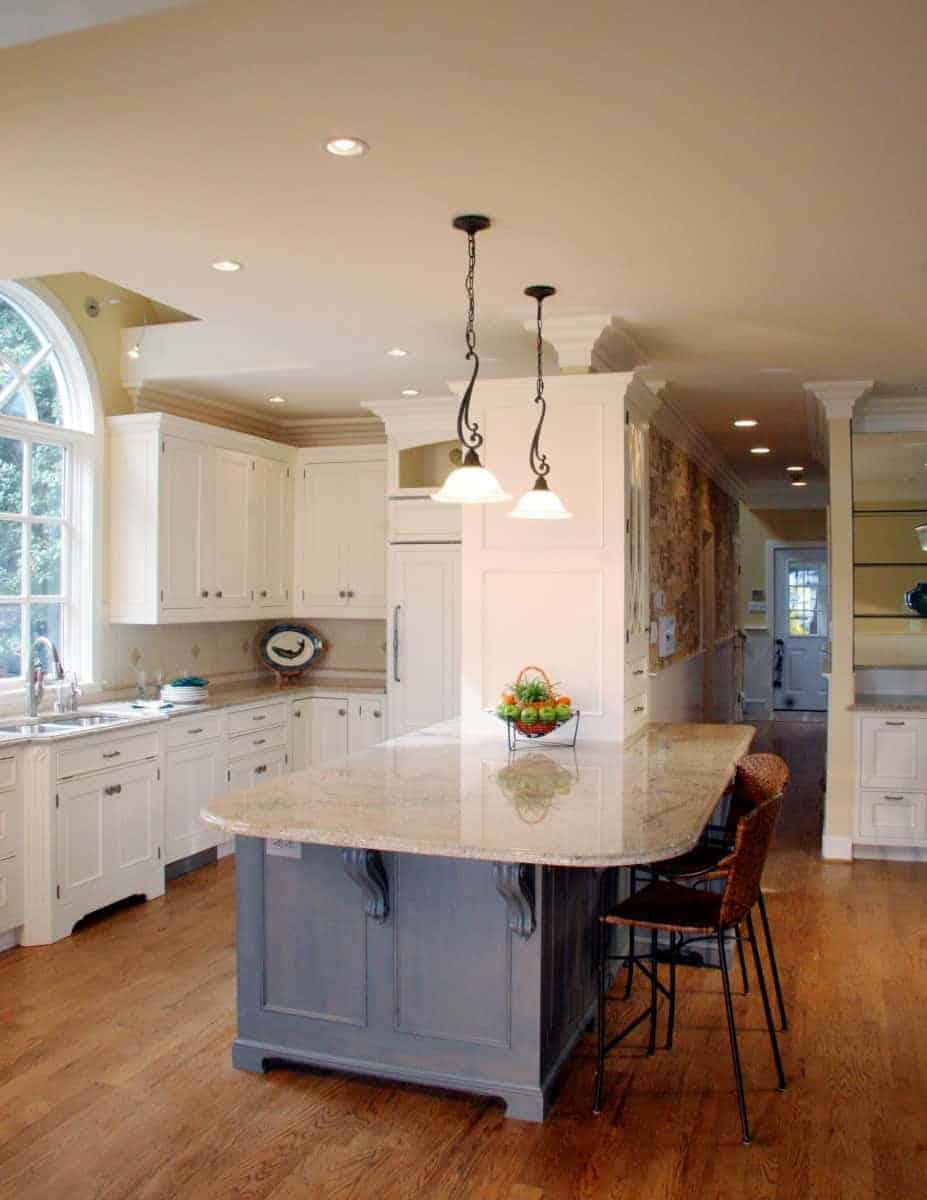 Modern kitchen with a central island, granite countertops, and elegant pendant lighting by Villa Builders in Annapolis, Maryland