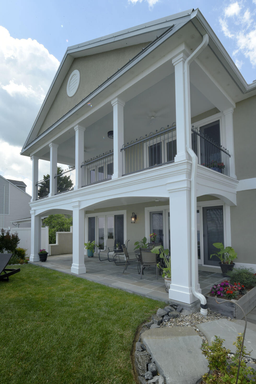 Spacious backyard with a double-deck patio and white columns, part of a remodel by Villa Builders in Annapolis, MD