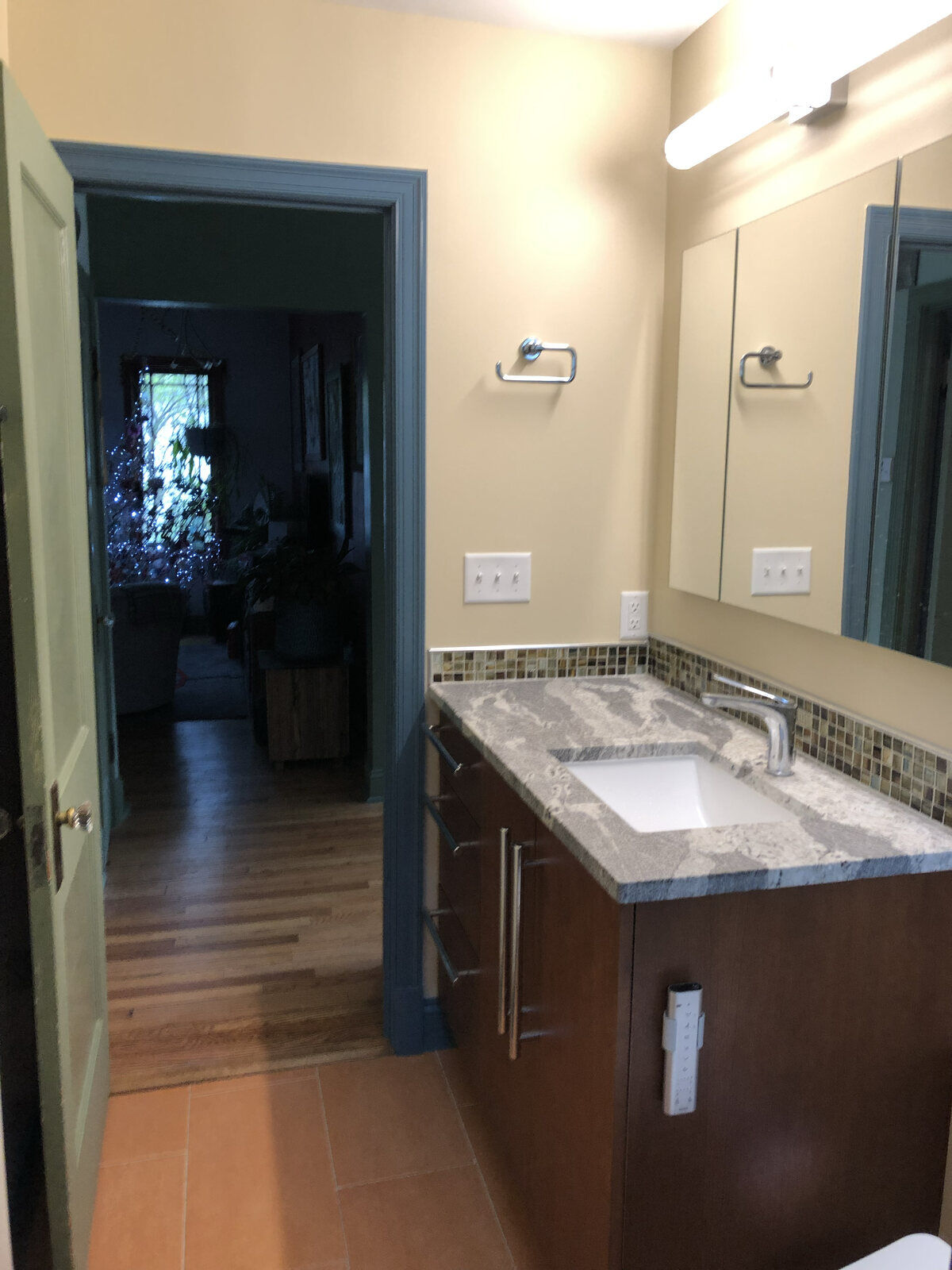 Updated bathroom design with granite countertops and a wood vanity by Villa Builders in Annapolis, MD